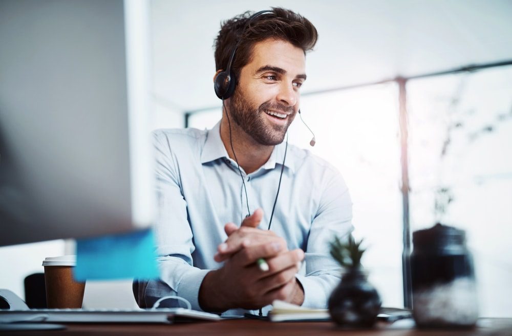 Virtual assistant posing for a picture by a computer