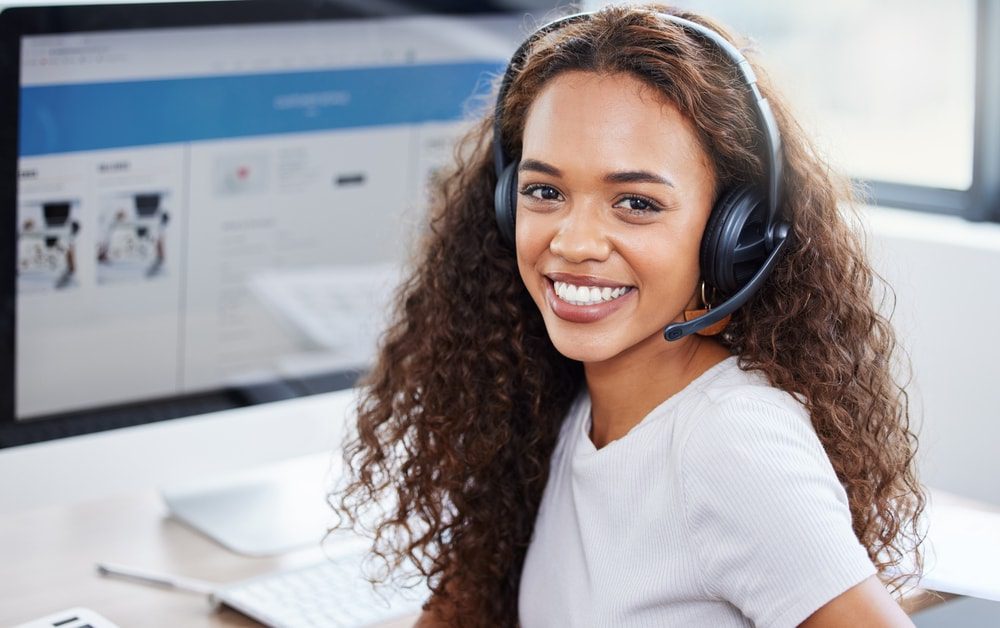 Virtual assistant posing for a picture by a computer